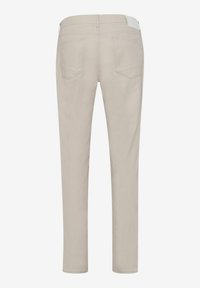 Beige slim-fit pants with a smooth texture, two back pockets, and a white accent on the waistband, featuring stitched detailing.