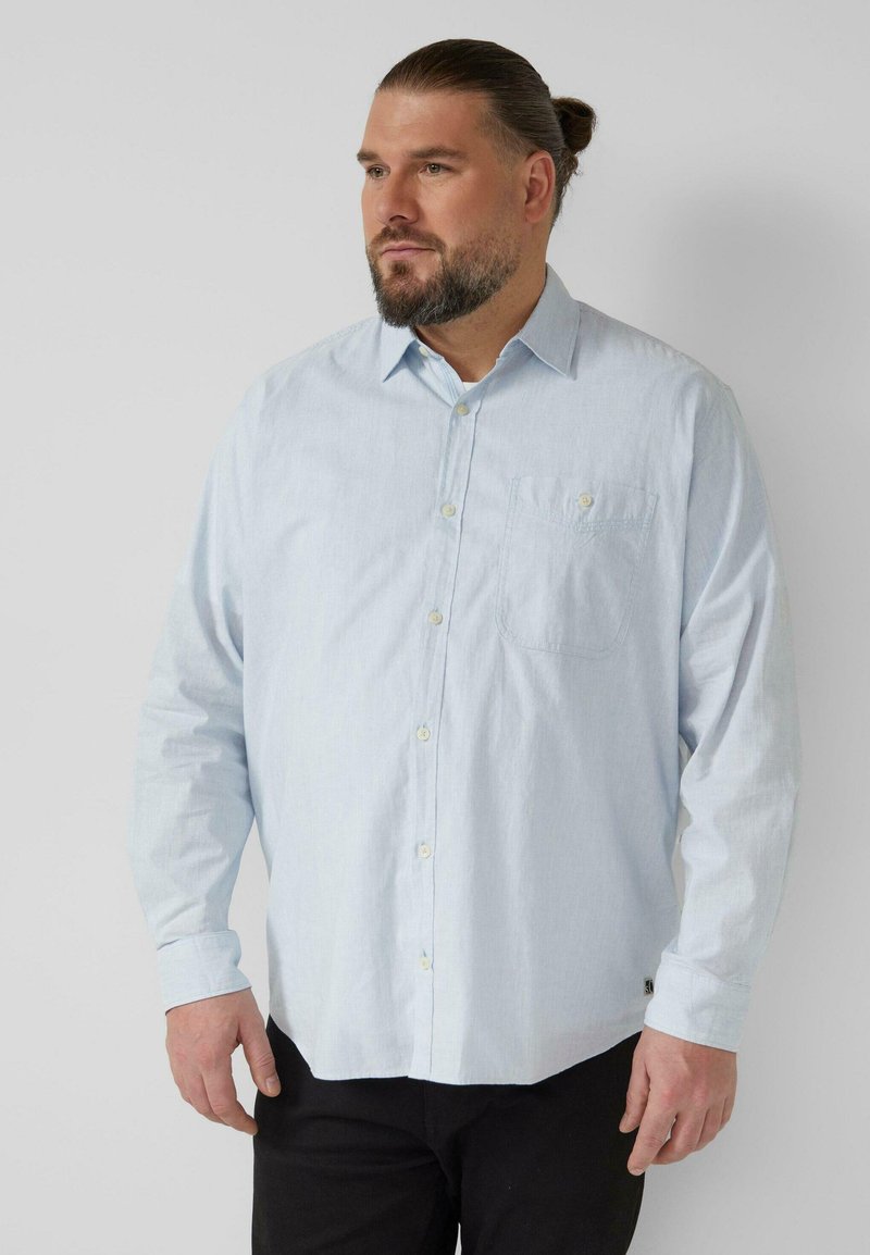 Hellblaues Langarmhemd mit Knopfleiste und Brusttasche. Hergestellt aus strukturiertem Stoff, mit spitzem Kragen und Knopfverschluss.