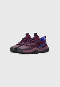 Purple and blue athletic shoes with black textured soles, mesh and leather upper, elastic laces, and a branded band on the side.
