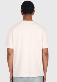 Lys beige bomulls T-skjorte med korte ermer, rund hals og en avslappet passform. Bakdelen har en jevn tekstur og ingen synlige logoer.