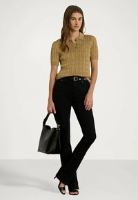 Moteris vilki garstyčių spalvos pintą trumpų rankovių polo marškinėlį, juodas aukšto liemens kelnes, juodus paplūdimio sandalus ir laiko juodą rankinę.