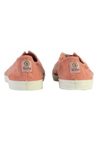 Scarpe di tela rosa con superficie testurizzata, suole in gomma bianca e una patch con logo sul retro. Design semplice con forma arrotondata.