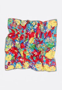 Colorful silk scarf featuring a vibrant floral pattern on a red background, with shades of yellow, blue, and green, bordered by a gray edge.