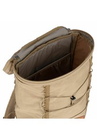 Zaino marrone chiaro con forma rotonda, apertura zip superiore, pannelli laterali in rete e accenti esterni in corda bungee. Internamente presenta un compartimento imbottito.