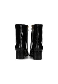 Bottines noires avec une finition brillante et des talons épais, dotées de zippes sur les côtés, montrées de l'arrière.