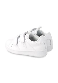 Deportivas blancas con una parte superior sintética suave, doble tiras de velcro, un collar acolchado y una suela de goma texturizada para tracción.