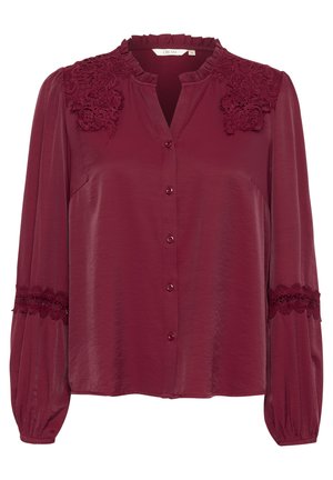 Burgundy blus med volangkrage, blommönstrad spetsdetalj på axlar och ärmar, knappstängning framtill och långa puffärmar.