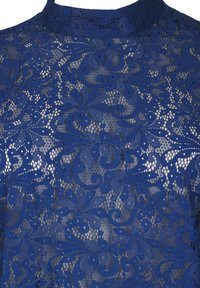 Tissu en dentelle bleue avec motifs floraux et feuillus et fond en maille transparente sur un vêtement à col montant.