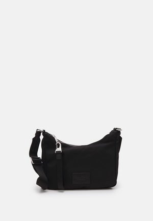 Black shoulder bag with adjustable strap, silver zipper and buckle, rectangular shape, plain design on light gray background.