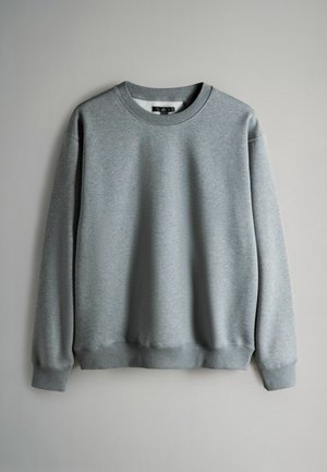 Felpa grigia realizzata in tessuto morbido, con scollatura rotonda e polsini a coste. Design semplice e minimale, senza motivi o dettagli visibili.