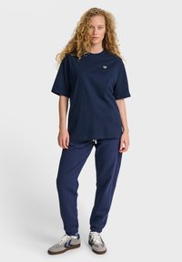 Mörkblå bomullsoversize t-shirt med rund hals och korta ärmar, ihop med matchande joggingbyxor med elastiska muddar och dragsko.