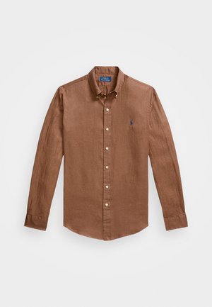 Chemise à manches longues marron en lin, avec un col classique, des boutons à l'avant et un petit logo bleu sur la poitrine.