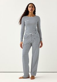 Randigt pyjamaset med långärmad tröja i marinblått och vitt. Överdelen har en rund halsringning och byxorna har en justerbar dragsko i midjan.