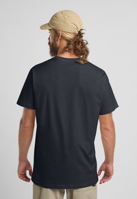 Marineblauwe katoenen T-shirt met korte mouwen, met een losse pasvorm en rechte snit. Gladde textuur met een eenvoudig ontwerp, zonder zichtbare logo's.