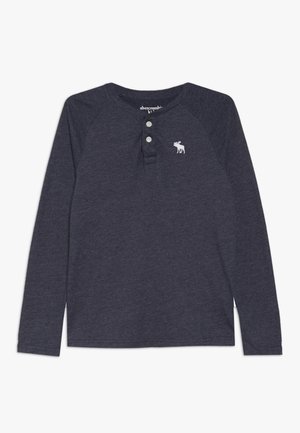 Ciemnoszara koszulka henley z długim rękawem, z dwoma guzikami i małym białym logo łosia na lewej piersi.