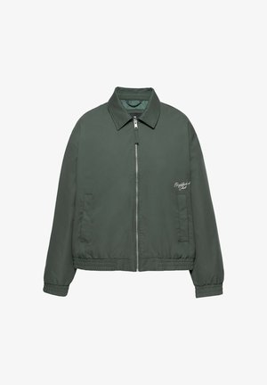 Veste zippée vert foncé avec col, poignets et ourlet élastiques, deux poches avant, et texte blanc sur la poitrine gauche indiquant "Neighborhood Club."