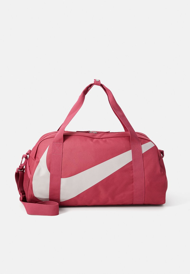Rosa nylon duffelväska med en stor vit Nike Swoosh-logotyp. Har dubbla handtag och en avtagbar axelrem för mångsidiga bäralternativ.