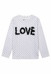 Chemise blanche à manches longues avec des pois noirs, présentant un graphique texturé "LOVE" en noir, col rond. Tissu doux.