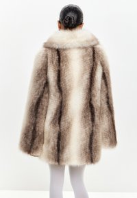 Cappotto in pelliccia sintetica nei toni del marrone e della crema, con un ampio colletto, maniche lunghe e motivo a righe verticali, finitura morbida e testurizzata.