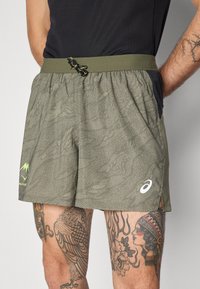 Menns grønne mønstrede shorts laget av lett stoff, med justerbar midje, sidelommer og en logo på benet.