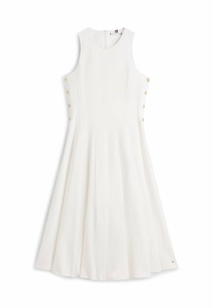 Robe midi blanche sans manches avec un col rond, une jupe évasée et des boutons dorés le long des deux côtés.