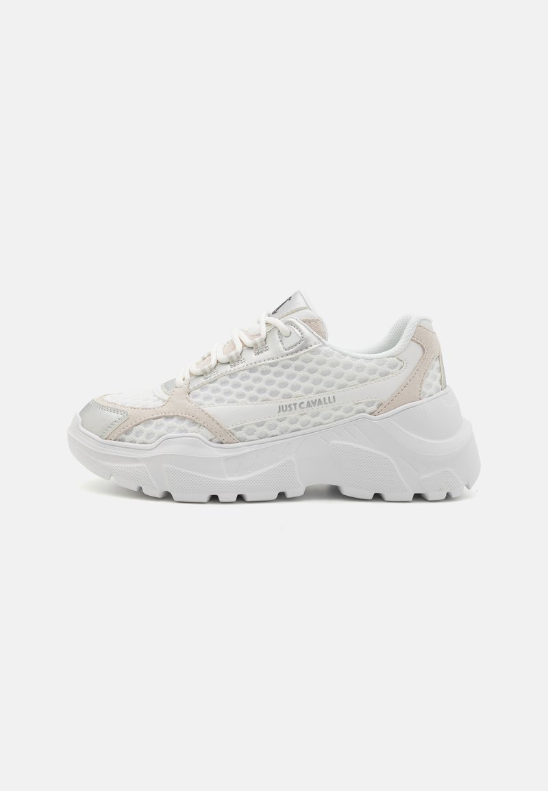 White mesh sneakers with silver and beige accents. Thick, textured outsole with a hexagonal pattern. Laces and padded collar for support.