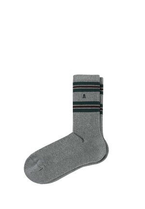 Chaussettes en coton grises avec une texture côtelée, ornées de rayures vertes et bordeaux en haut et d'un petit logo de skull près du revers.