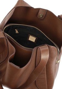 Brown leather tote bag with a textured surface, featuring a zippered interior pocket and a gold-tone hardware accent.