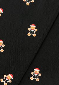 Sort stof med m�ønster af små peberkagemænd iført nissehuer, røde butterflyer og sorte jakkesæt med grønne og røde knapper.