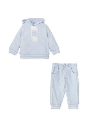 Chándal para niño pequeño en azul claro que incluye una sudadera con capucha, un bolsillo frontal y detalles a rayas, acompañada de pantalones a juego con cinturilla elástica.