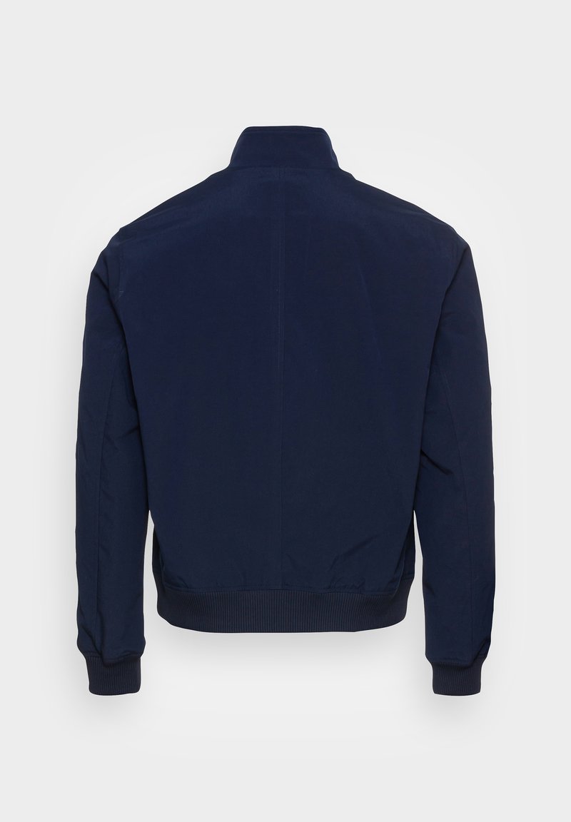 Veste bomber bleu marine avec col haut, poignets et ourlet côtelés. Le tissu semble lisse et durable, avec un design simple et épuré.