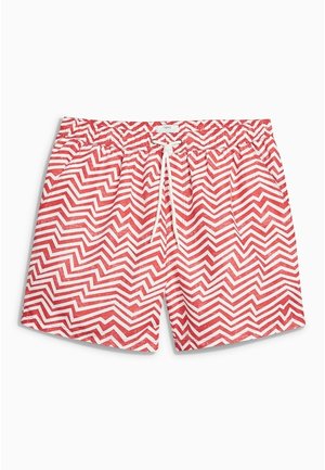 Short de bain rouge et blanc à motif zigzag, avec cordon blanc, ceinture élastique, poches avant et coupe décontractée.