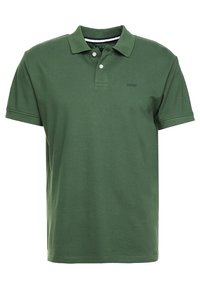 Grön pikétröja i bomull med klassisk krage, två knappar i placket och en diskret broderad logotyp på bröstet.