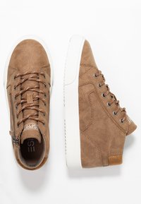 Baskets montantes en daim marron avec semelles en caoutchouc blanches, fermeture à lacets sur le devant et fermeture éclair latérale. Comprennent des accents cousus et des surfaces texturées.