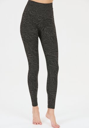 Zwarte leggings met een subtiel zebra-patroon, hoge taille, gemaakt van een rekbare stof die zich vormt naar de benen en voeten.