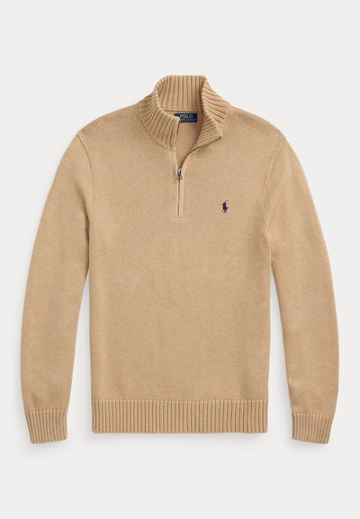 Bézs kötött pulóver negyed cipzárral és egy kis sötétkék Polo Ralph Lauren logóval a bal mellkason.