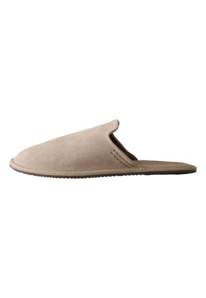 Chausson beige en daim à enfiler avec bout fermé, dos ouvert, semelle plate et coutures discrètes sur le côté.