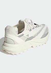 Biele atletické tenisky s vrchnou časťou z jemnej siete a semišu, zaoblenou špičkou, štruktúrovanými bočnými panelmi a elastickým systémom šnurovania. Hrubá gumová podrážka.