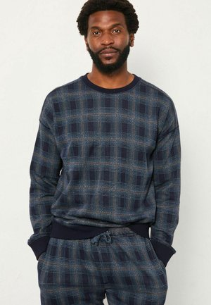Navy blue checkered sweatshirt made of soft fabric, featuring ribbed cuffs and hem, with a subtle plaid pattern in blue and orange accents.