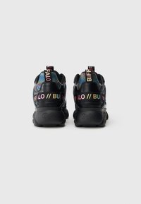 Μαύρα αθλητικά παπούτσια με υφή και χοντρή σόλα. Διαθέτουν πολύχρωμο λογότυπο και λεπτομέρειες στη φτέρνα και στη γλώσσα.