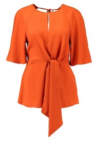 Blouse orange à manches courtes, avec ceinture à nouer à la taille et encolure en trou de serrure. Confectionnée dans un tissu lisse, elle présente une coupe décontractée et une silhouette fluide.
