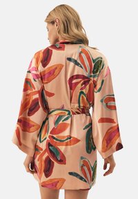 Kimono w kwiatowym wzorze z długimi rękawami, wykonane z jedwabistego materiału w brzoskwiniowych odcieniach, z intensywnymi kolorami czerwieni, zieleni i różu, zwężane w talii.