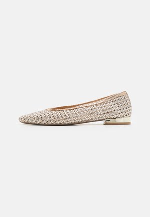 Chaussure plate beige tissée avec bout arrondi et talon métallique doré bas, vue de profil sur fond blanc.