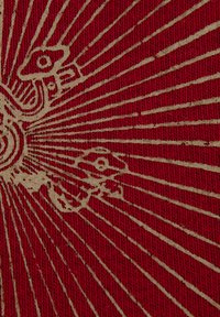 Czerwony materiał o fakturowanej powierzchni, z złotym wzorem przedstawiającym promienie i stylizowane elementy, tworzący uderzający wzór.