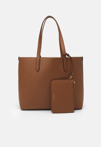 Hnědá kožená taška přes rameno s texturou, dvěma dlouhými ušima a menší odpovídající zipovou kapsou, která je připevněná. Čisté linie a jednoduchý design.