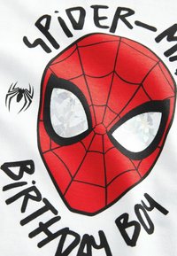 Röd Spider-Man-maskgrafik på en vit tygtröja, med svarta konturer och texten "FÖDELSEDAGSKILLING" i svarta bokstäver.