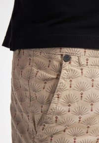 Shorts beige con motivo a fanelle grigie e rosse, con chiusura a pulsante e dettagli di cucitura in vista. Tessuto morbido, vestibilità casual.