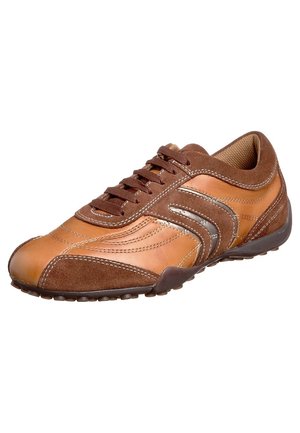 Chaussure de sport en cuir marron et daim avec fermeture à lacets, design à bandes courbées, semelle en caoutchouc et zone d'orteils renforcée.