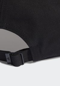 Gorra de tela negra con superficie texturizada, correa ajustable con hebilla y un distintivo logo bordado cerca de la correa.