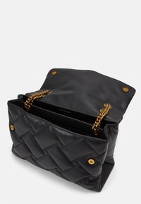 Svart läderhandväska med vävd struktur, med ett axelband i guldkedja och tryckknappar på en klaff, som visar ett rymligt inre.